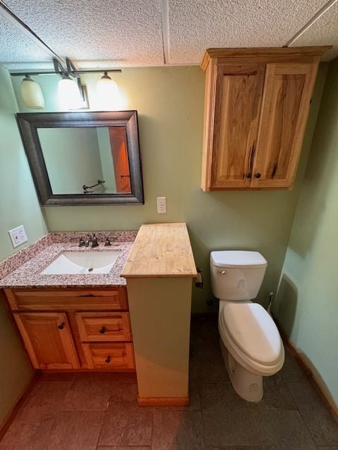 bathroom featuring tile patterned floors, vanity, toilet, and a textured ceiling