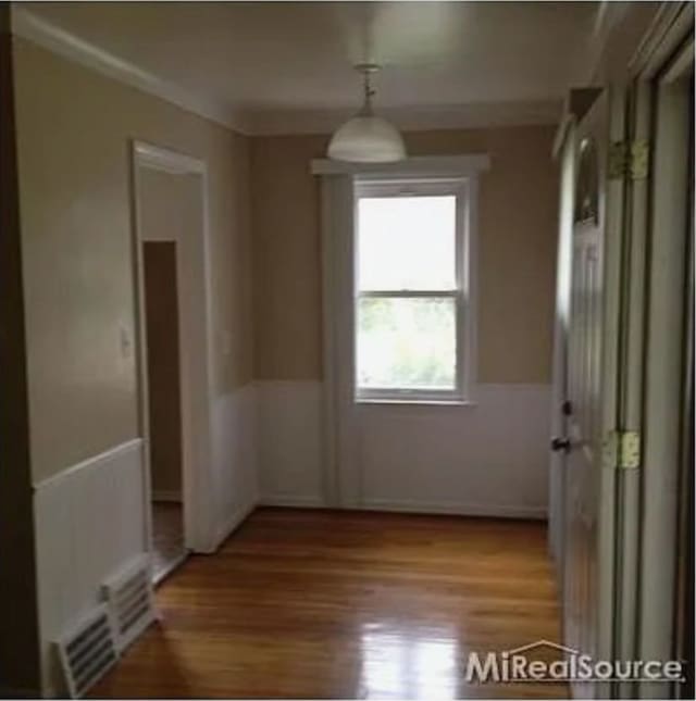 spare room featuring light hardwood / wood-style flooring and ornamental molding