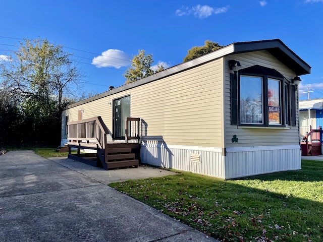 3924 W Jefferson Ave Unit 3924, Trenton, MI 48183 - view of side of home featuring a deck and a lawn