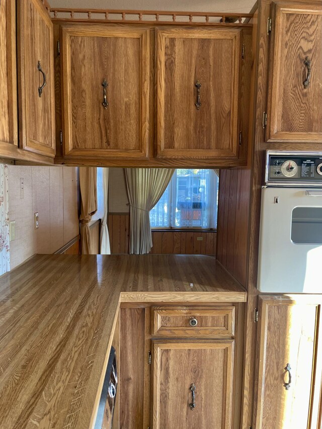 3924 W Jefferson Ave Unit 3924, Trenton, MI 48183 - kitchen view of brown cabinets, white oven, and wood walls