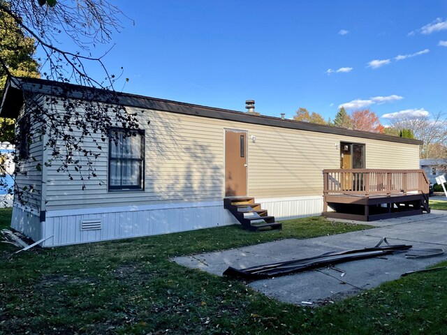 3924 W Jefferson Ave Unit 3924, Trenton, MI 48183 - rear view of property with entry steps, a lawn, and a wooden deck