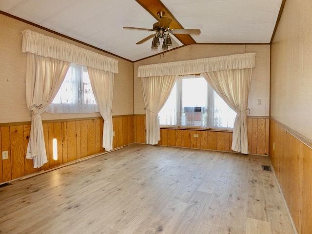 bonus room with plenty of natural light, light wood-type flooring, wooden walls, and vaulted ceiling