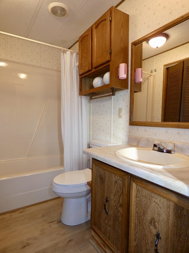 3924 W Jefferson Ave Unit 3924, Trenton, MI 48183 - bathroom featuring vanity, toilet, wallpapered walls, shower / tub combo, and wood finished floors