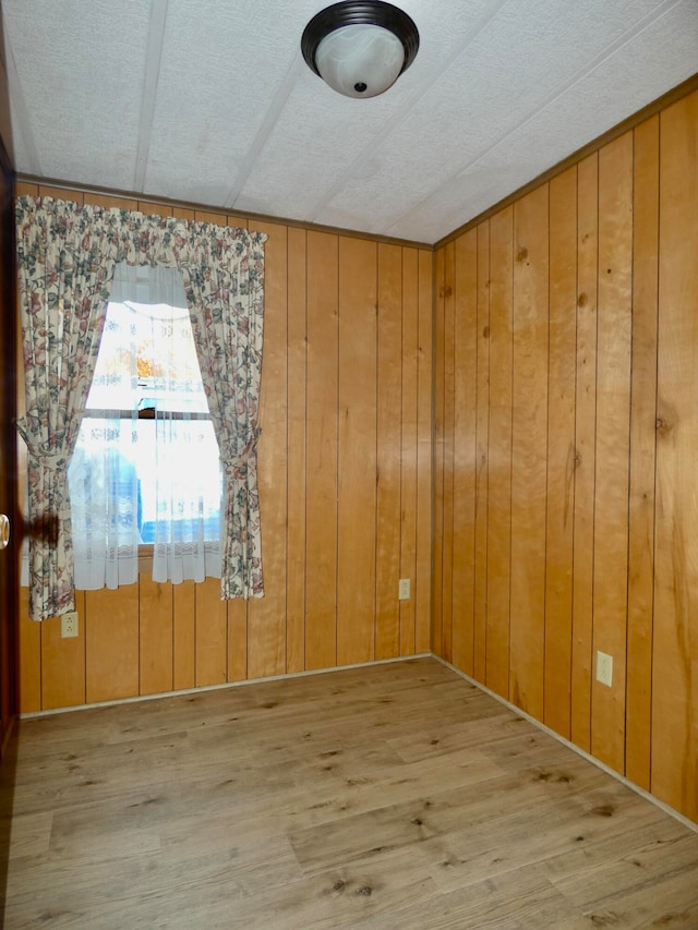 unfurnished room featuring wooden walls and hardwood / wood-style flooring