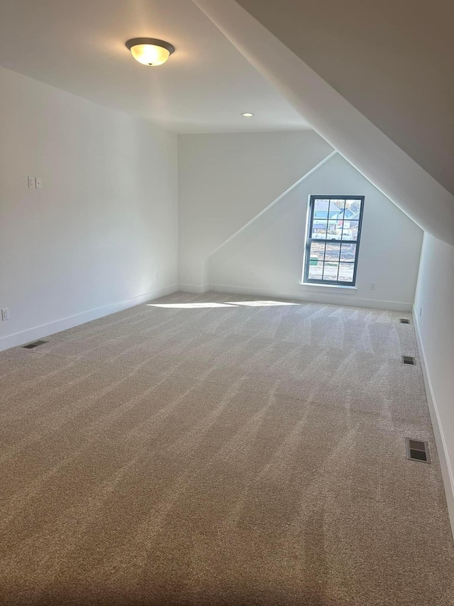 additional living space with carpet floors and lofted ceiling