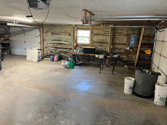 garage with a garage door opener and electric panel