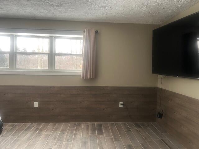 empty room with hardwood / wood-style floors and a textured ceiling