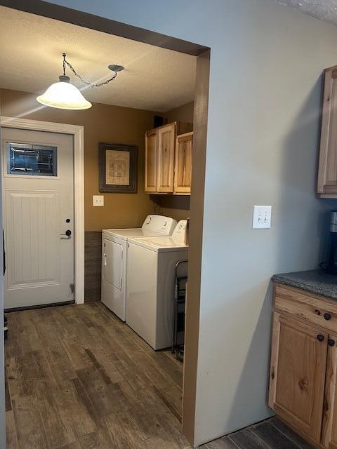 clothes washing area with cabinets, dark hardwood / wood-style floors, independent washer and dryer, and a textured ceiling