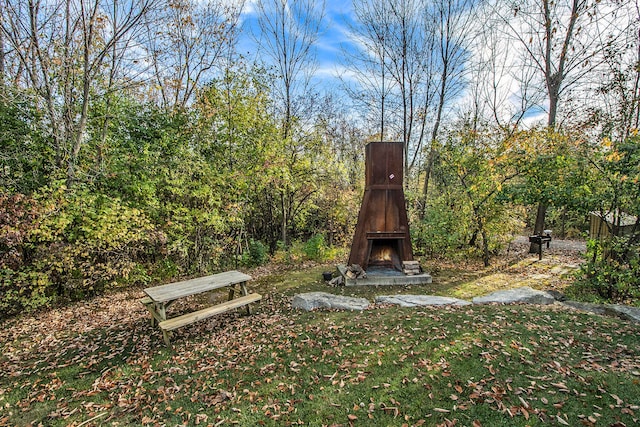 view of yard with exterior fireplace