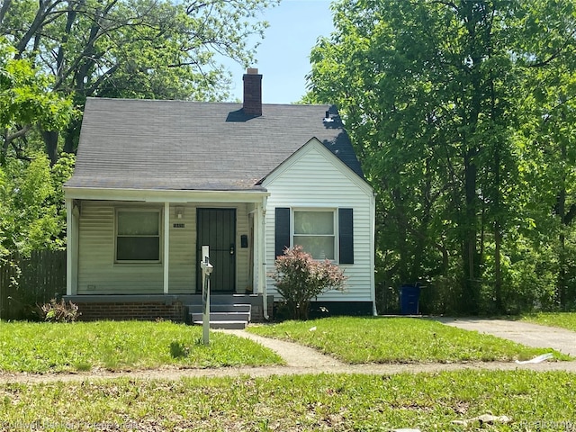 18498 Fielding St, Detroit, MI 48219 - view of front of house featuring a chimney, covered porch, and a front yard