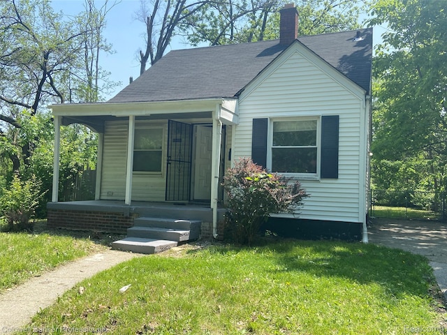 18498 Fielding St, Detroit, MI 48219 - bungalow featuring a porch, a front lawn, a chimney, and roof with shingles