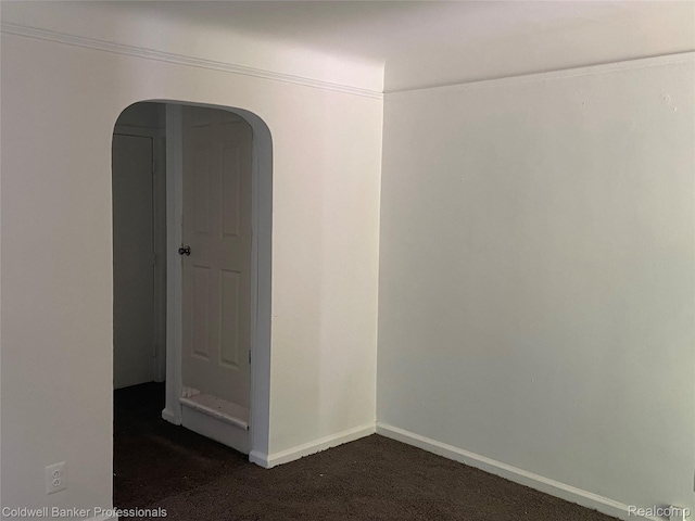 18498 Fielding St, Detroit, MI 48219 - empty room featuring dark colored carpet, arched walkways, and baseboards