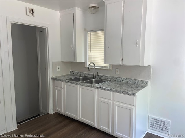 18498 Fielding St, Detroit, MI 48219 - kitchen with a sink, dark wood-style flooring, and white cabinetry
