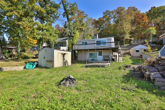 rear view of house with a lawn, a shed, and a wooden deck