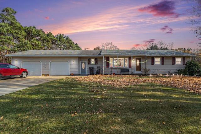 ranch-style house featuring a garage and a lawn