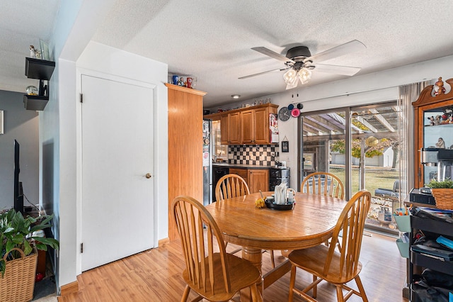 dining space with ceiling fan, a textured ceiling, and light hardwood / wood-style flooring