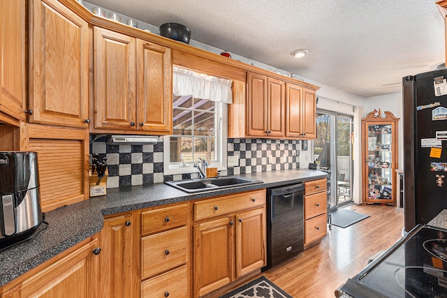 kitchen featuring black appliances, plenty of natural light, light wood-type flooring, and tasteful backsplash