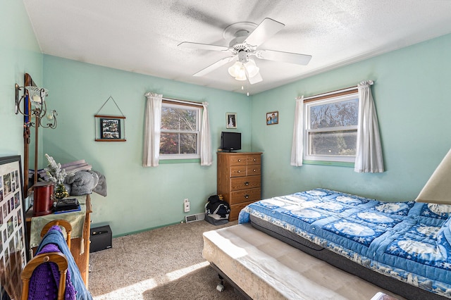 carpeted bedroom with a textured ceiling and ceiling fan