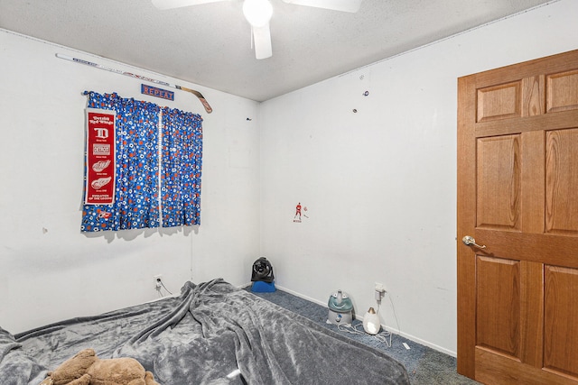 carpeted bedroom featuring ceiling fan and a textured ceiling