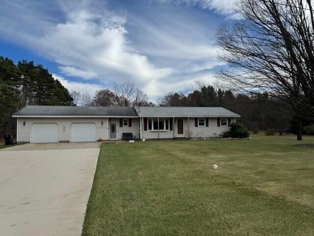 ranch-style house featuring a garage and a front lawn