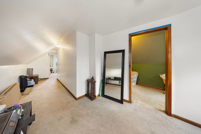 additional living space with light colored carpet and vaulted ceiling