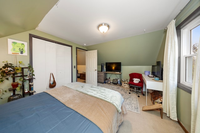 carpeted bedroom with lofted ceiling