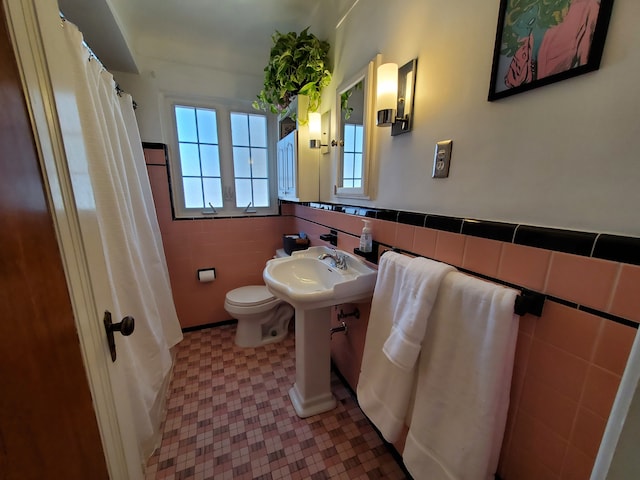 bathroom featuring tile walls and toilet