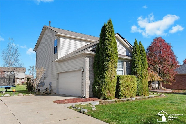 view of side of home with a trampoline, a garage, and a lawn