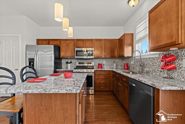 kitchen featuring dark hardwood / wood-style flooring, tasteful backsplash, stainless steel appliances, sink, and decorative light fixtures