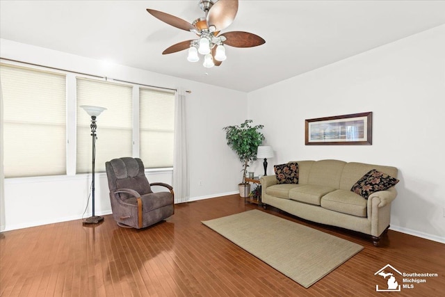 living room featuring ceiling fan and dark hardwood / wood-style floors