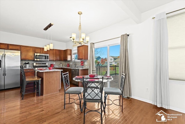 dining area featuring beam ceiling, dark hardwood / wood-style flooring, sink, and an inviting chandelier