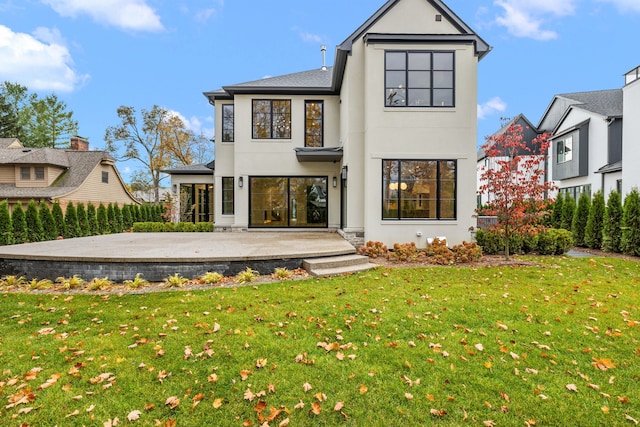 rear view of property featuring a patio and a lawn