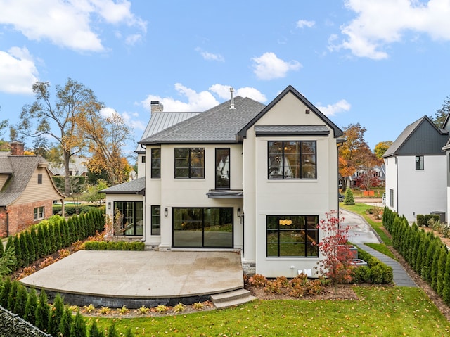 back of property featuring a patio area and a yard