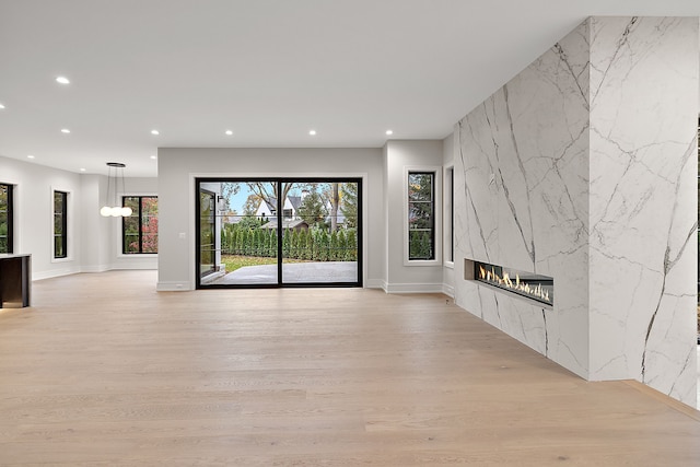 unfurnished living room featuring light hardwood / wood-style flooring and a high end fireplace