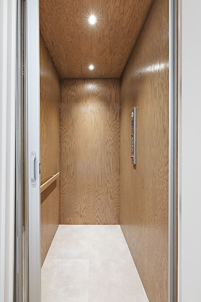 room details with elevator, wood walls, and wood ceiling