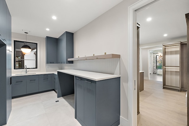 kitchen featuring decorative light fixtures, light hardwood / wood-style flooring, and sink