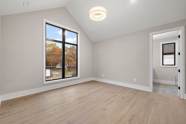 empty room with light hardwood / wood-style floors and vaulted ceiling