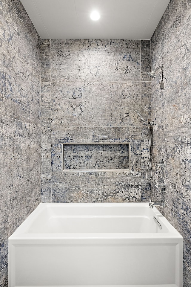 bathroom featuring tiled shower / bath and tile walls