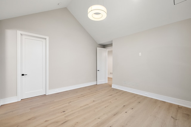 empty room featuring light wood-type flooring and lofted ceiling