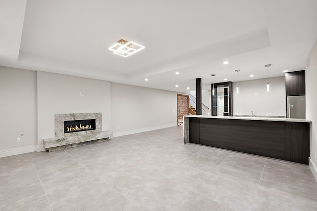 unfurnished living room with sink and a high end fireplace