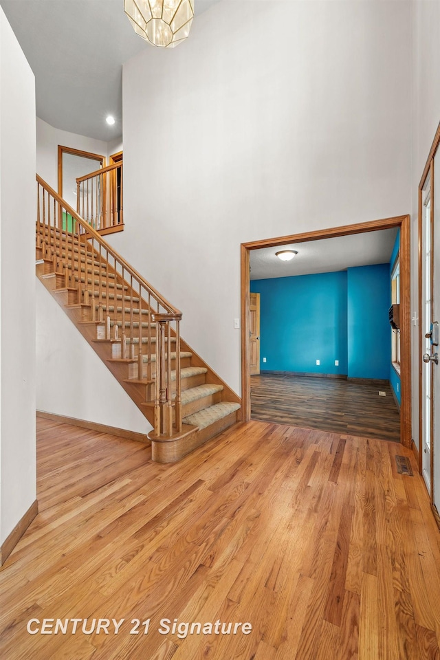 unfurnished living room with a notable chandelier and hardwood / wood-style flooring