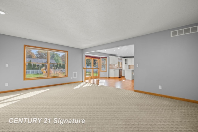 carpeted spare room featuring a textured ceiling