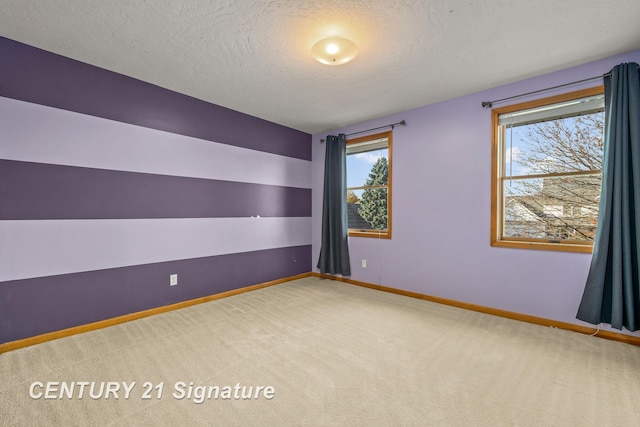 carpeted empty room with a textured ceiling and plenty of natural light