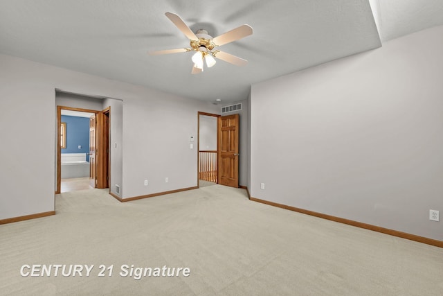 unfurnished bedroom featuring ceiling fan, light colored carpet, and connected bathroom