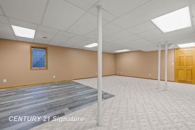 basement with hardwood / wood-style floors and a paneled ceiling