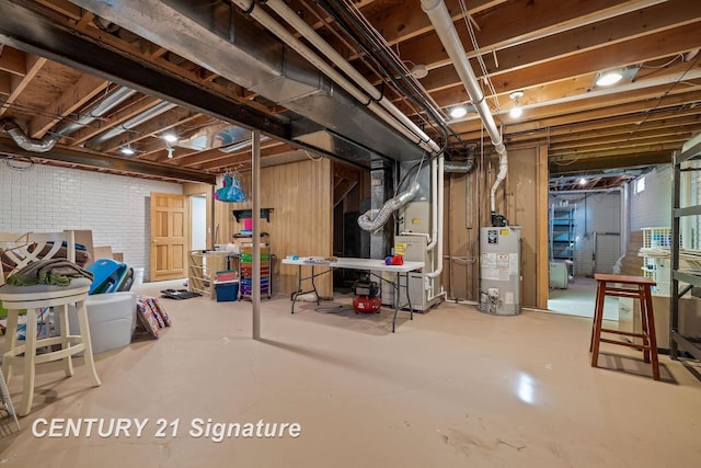 basement with gas water heater, heating unit, and brick wall