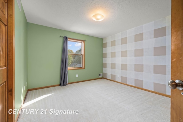 unfurnished room featuring carpet and a textured ceiling