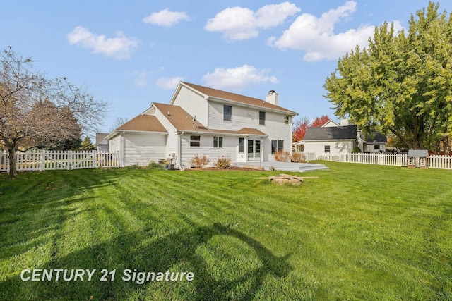 rear view of property featuring a lawn