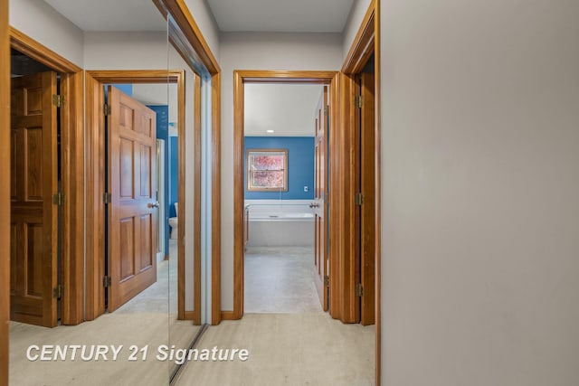 hallway featuring light colored carpet