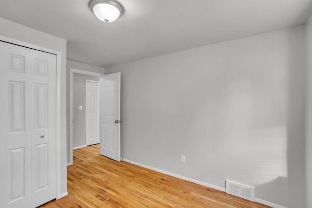 unfurnished bedroom featuring a closet and light hardwood / wood-style flooring